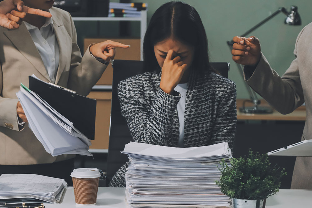 Group of business professionals discussing documents in an office, representing evaluation of workplace discrimination issues and policies