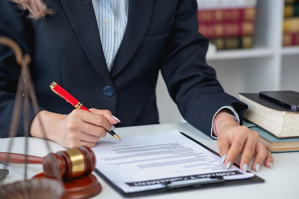 Employment lawyer consulting with client about workplace discrimination and reviewing legal documents at an office desk