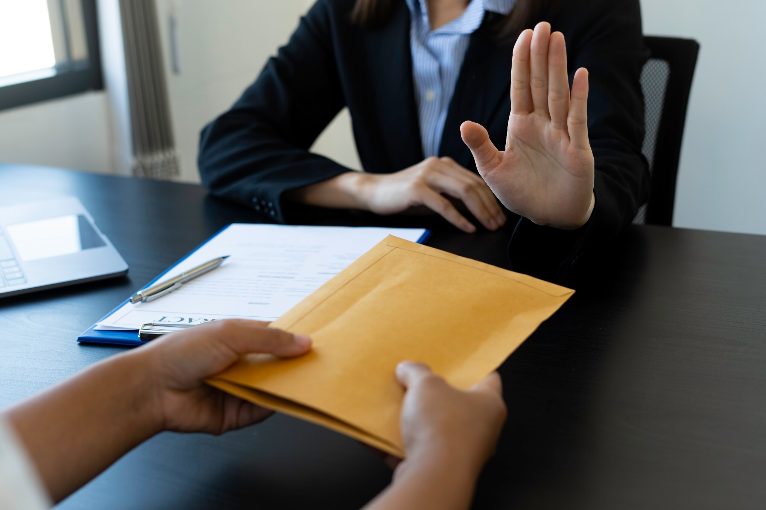 florida-false-claims-act-qui-tam-guide-2 Employee rejecting a bribe, illustrating whistleblower protections under Florida’s False Claims Act for fraud reporting.