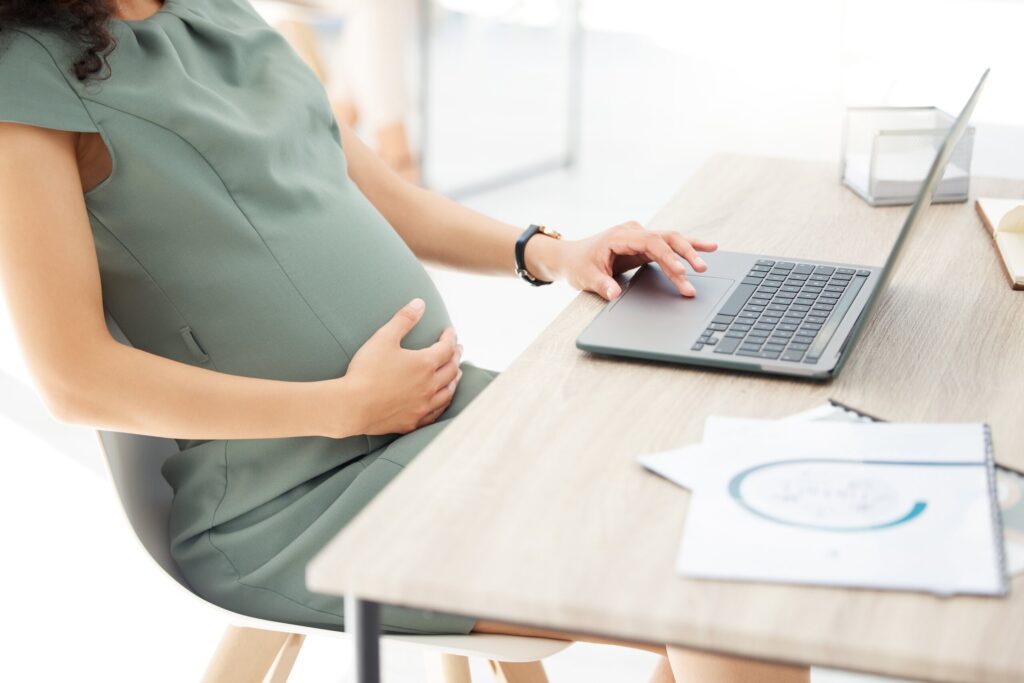 Pregnant employee working at a desk, representing Florida maternity leave rights and employee protections during pregnancy.