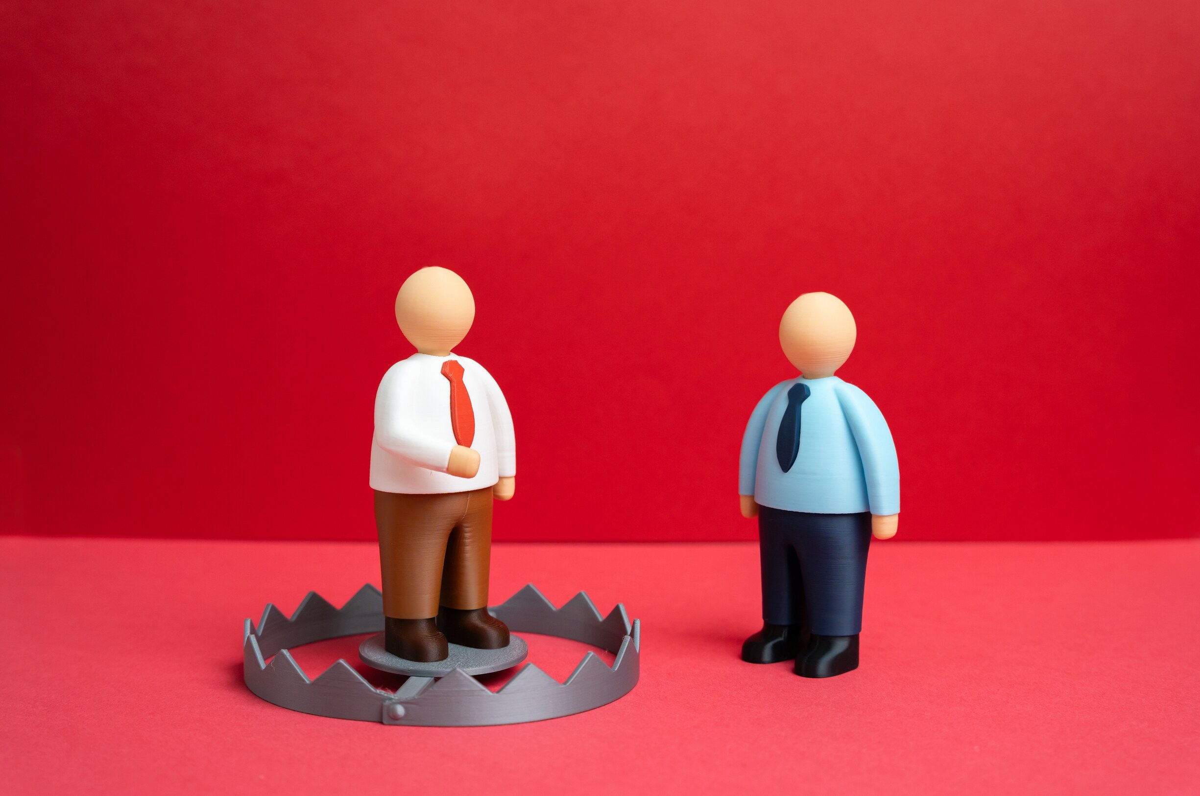 Single red figure separated from a group, illustrating the difference between hostile work environment and quid pro quo sexual harassment in Florida.